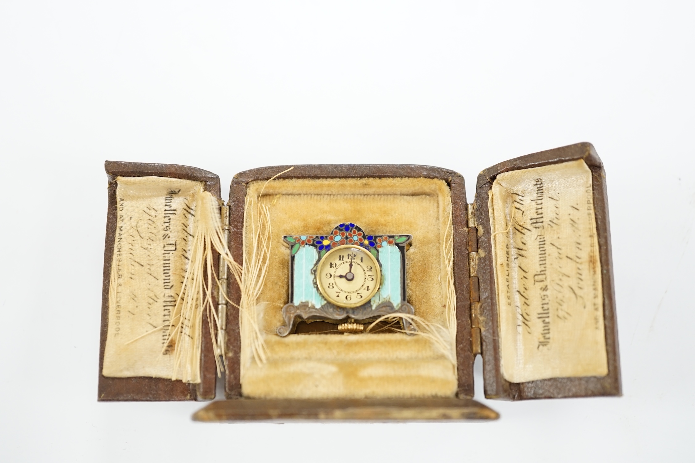 A miniature enamel timepiece modelled as a mantle clock, with watch movement, 2cm high, in fitted case